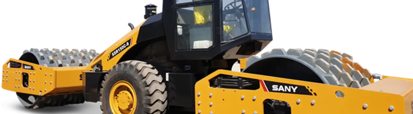 New flatbed equipment parked at a construction site, ready for loading materials with safety barriers nearby.