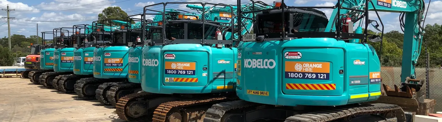 A variety of construction equipment neatly arranged on the ground outdoors, ready for use or demonstration.