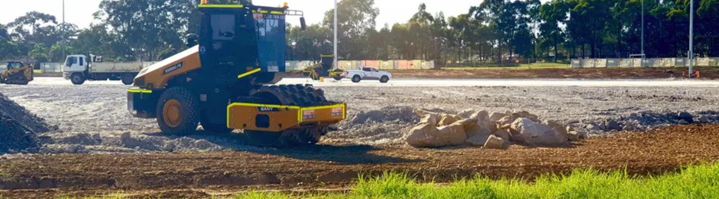 A padfoot roller compacting soil on a construction site, preparing the ground for stable infrastructure development.