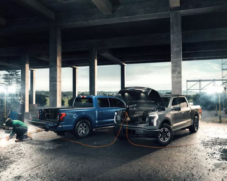 two electric ford trucks at a worksite