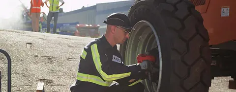 worker checking equipment tires