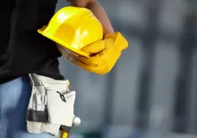 man holding hard hat wearing gloves