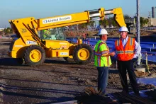 Discussing Plans Near Earthmoving Equipment