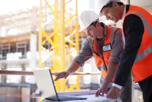 men working at computer at jobsite