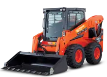 Side view of a loader truck at a construction site, used for moving heavy materials near safety barriers.