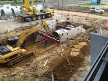Multiple machines and equipment excavating soil at a construction site, preparing the ground for building foundations or infrastructure.