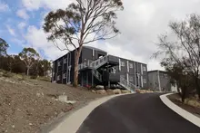 Student dormitory constructed from stacked shipping containers, featuring modern design and communal living spaces.